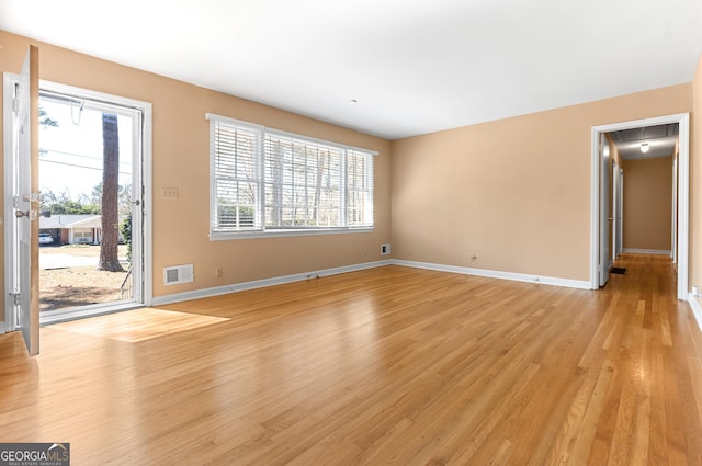 unfurnished living room featuring light wood-type flooring, visible vents, and baseboards