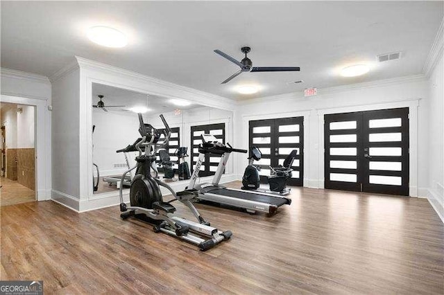 workout room featuring french doors, visible vents, crown molding, and wood finished floors