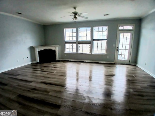 unfurnished living room with plenty of natural light, a fireplace, visible vents, and dark wood-type flooring