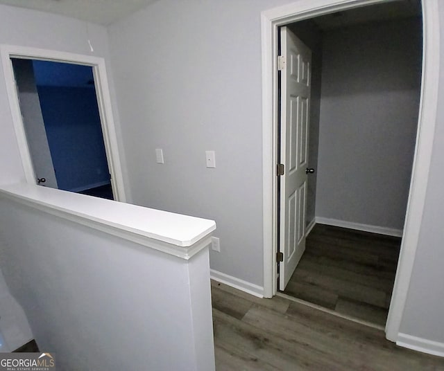 hallway featuring baseboards and wood finished floors