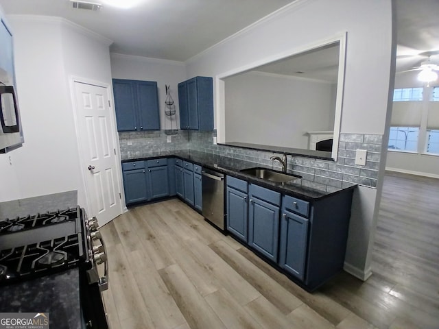 kitchen featuring blue cabinetry, decorative backsplash, gas stove, a sink, and dishwasher