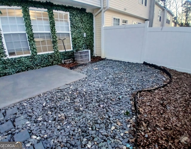 view of yard with central AC unit and fence