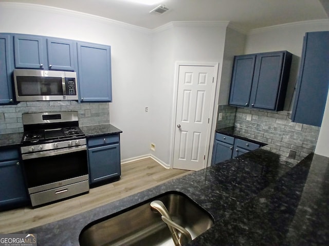 kitchen featuring dark stone counters, stainless steel appliances, ornamental molding, and visible vents