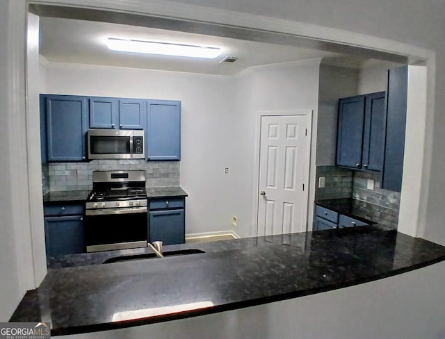 kitchen with appliances with stainless steel finishes, a sink, visible vents, and decorative backsplash