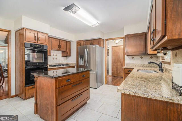 487 Glendale Ct, Stone Mountain, GA 30087 - kitchen with dobule oven black, stainless steel fridge with ice dispenser, light stone counters, gas cooktop, and a sink