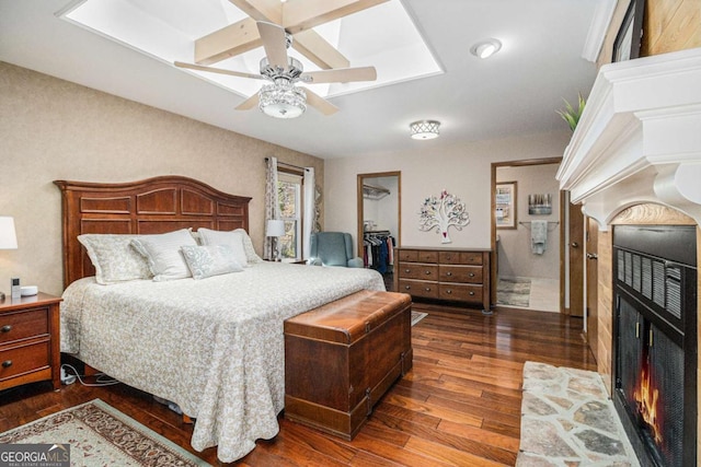487 Glendale Ct, Stone Mountain, GA 30087 - bedroom with a warm lit fireplace, a ceiling fan, hardwood / wood-style floors, a walk in closet, and a closet