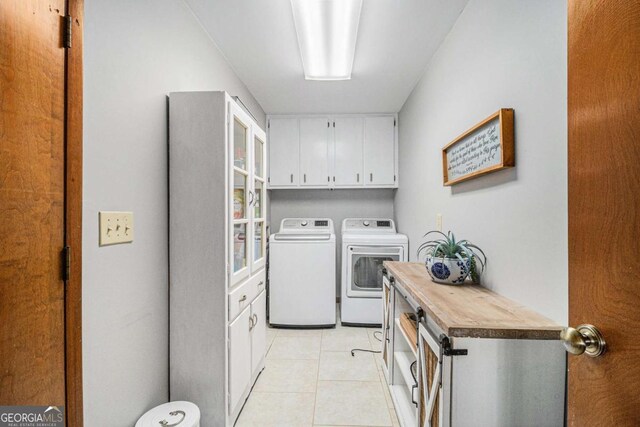 487 Glendale Ct, Stone Mountain, GA 30087 - laundry area with cabinet space, washing machine and clothes dryer, and light tile patterned floors