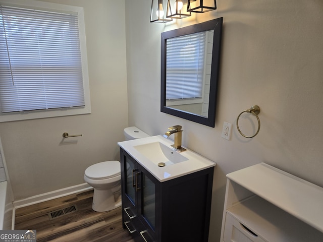 938 Rebel Forest Dr SE, Atlanta, GA 30315 - bathroom with toilet, wood finished floors, vanity, visible vents, and baseboards