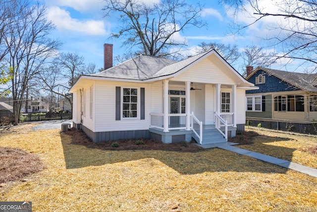 view of front of home featuring a ceiling fan, a chimney, fence, a porch, and a front yard