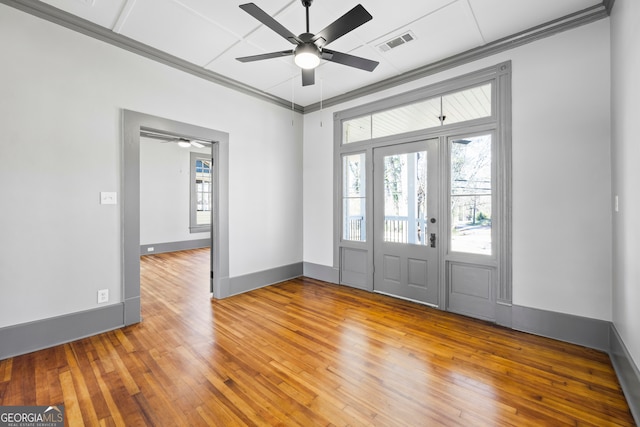 entrance foyer with hardwood / wood-style flooring, visible vents, a wealth of natural light, and ornamental molding