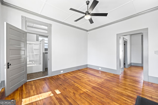 unfurnished bedroom featuring ornamental molding, wood-type flooring, baseboards, and a ceiling fan