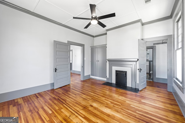unfurnished living room with light wood-style floors, a fireplace, and crown molding
