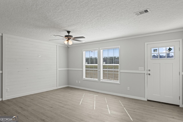 entryway featuring ceiling fan, a textured ceiling, visible vents, and light wood-style floors