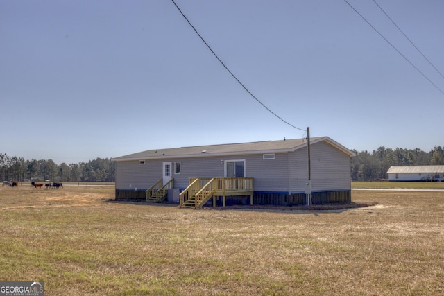 rear view of property with a deck and a lawn