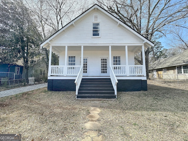 bungalow-style home featuring a porch, fence, and stairway