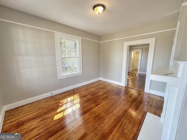 unfurnished room with wood finished floors and baseboards