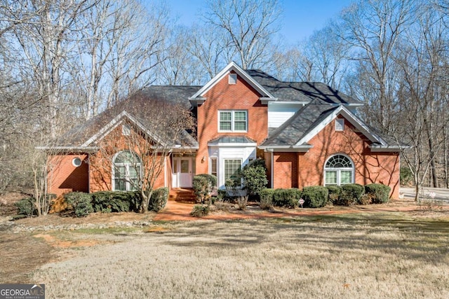 view of front facade featuring brick siding and a front lawn