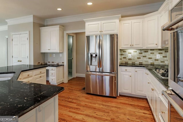 kitchen featuring stainless steel appliances, tasteful backsplash, ornamental molding, white cabinets, and light wood-type flooring