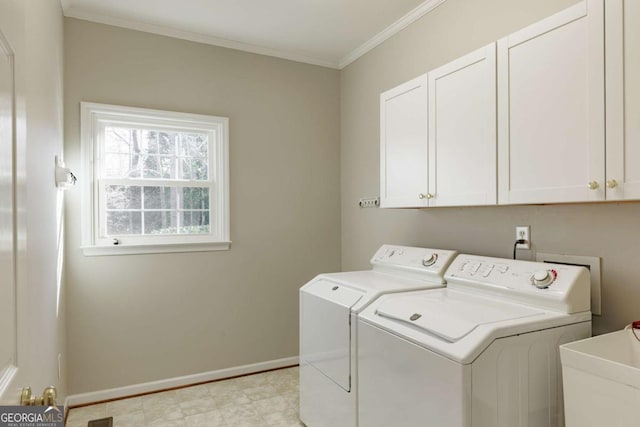 washroom featuring crown molding, cabinet space, a sink, independent washer and dryer, and baseboards