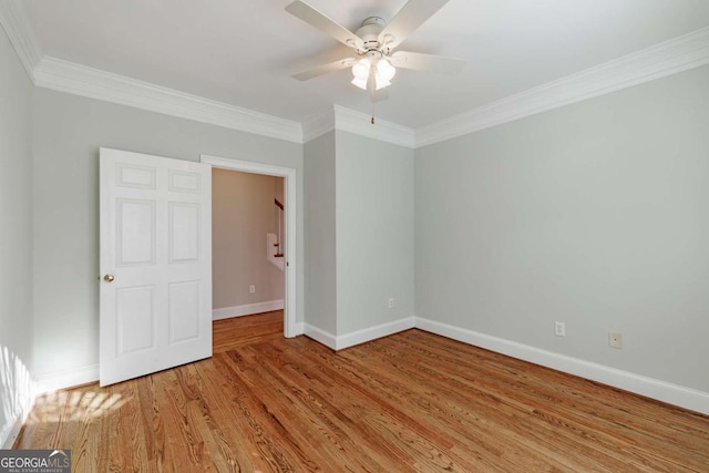 unfurnished bedroom with crown molding, ceiling fan, wood finished floors, and baseboards