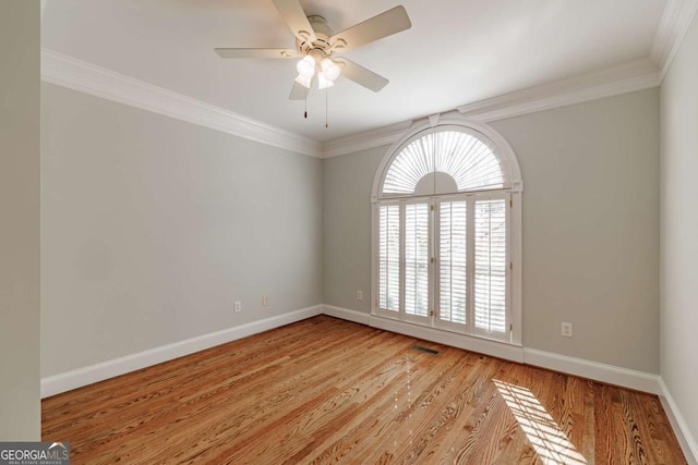 unfurnished room with ornamental molding, light wood-type flooring, visible vents, and baseboards