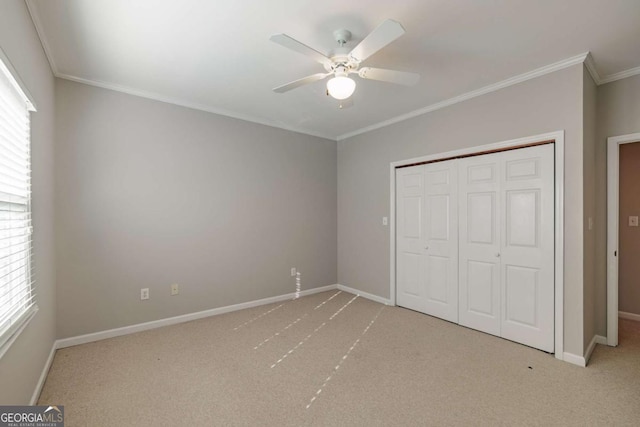 unfurnished bedroom featuring carpet floors, ornamental molding, a closet, and baseboards