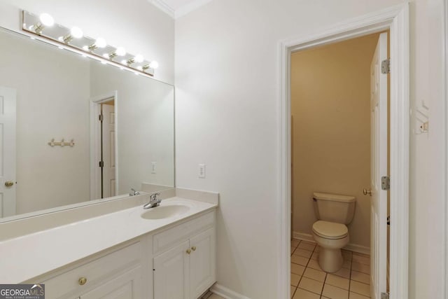 bathroom featuring toilet, tile patterned flooring, vanity, and baseboards