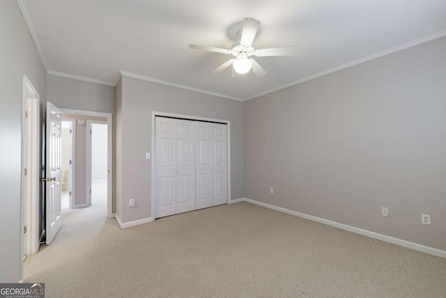 unfurnished bedroom featuring crown molding, a closet, a ceiling fan, light carpet, and baseboards