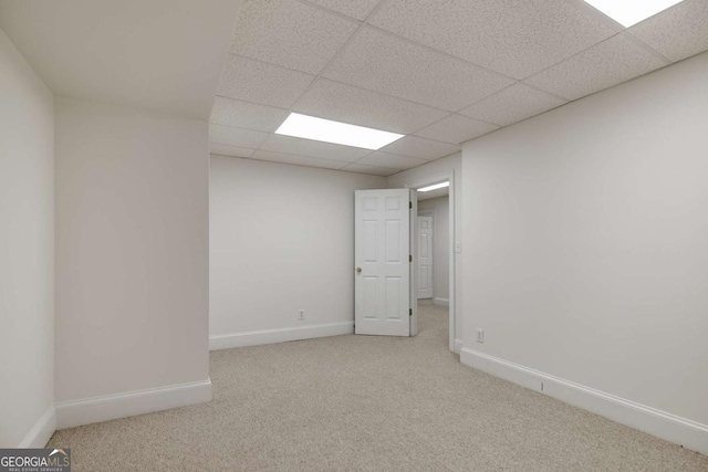 unfurnished room with carpet, a paneled ceiling, and baseboards