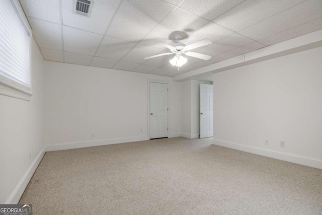 spare room with carpet, visible vents, ceiling fan, and a drop ceiling