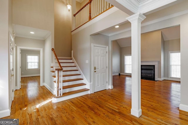 stairs with baseboards, a high ceiling, and wood finished floors