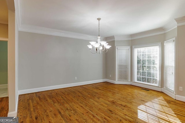 unfurnished dining area featuring a chandelier, baseboards, and wood finished floors