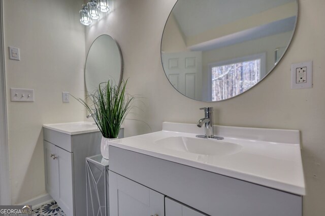 full bath with a sink, a shower, and two vanities