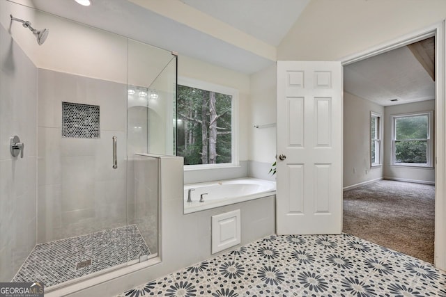 bathroom featuring lofted ceiling, a shower stall, and a bath