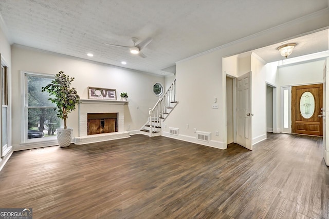 unfurnished living room featuring a fireplace, wood finished floors, visible vents, baseboards, and stairway