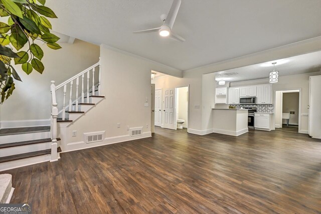 unfurnished living room featuring ornamental molding, dark wood finished floors, visible vents, and a fireplace with raised hearth