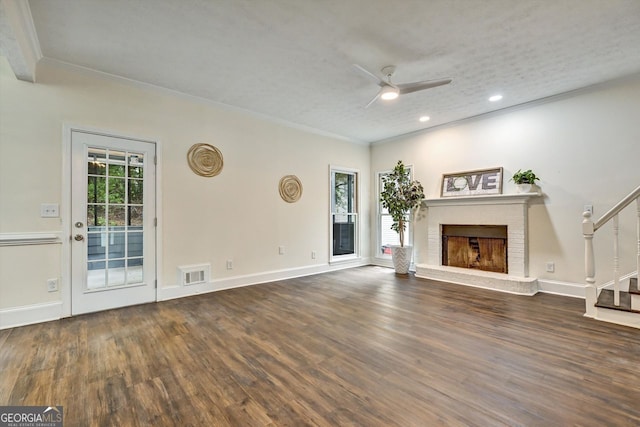 unfurnished living room featuring stairway, wood finished floors, visible vents, and crown molding