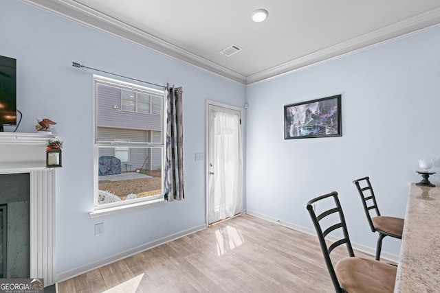 office space with visible vents, crown molding, baseboards, and wood finished floors