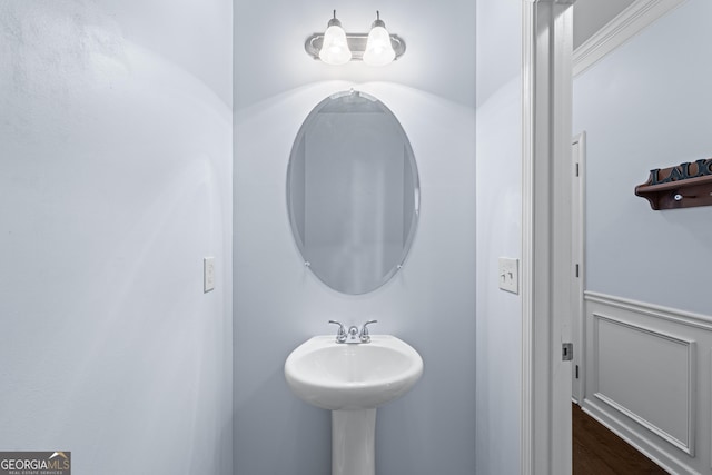 bathroom featuring a wainscoted wall and wood finished floors