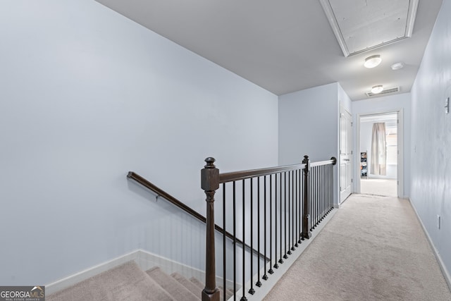 corridor featuring attic access, visible vents, baseboards, carpet, and an upstairs landing