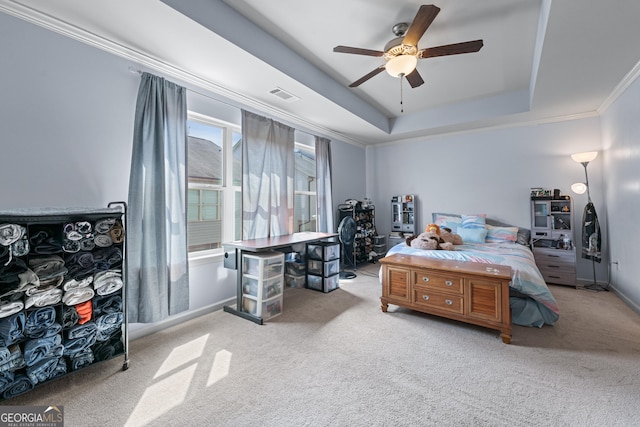 carpeted bedroom with ceiling fan, visible vents, baseboards, a raised ceiling, and crown molding