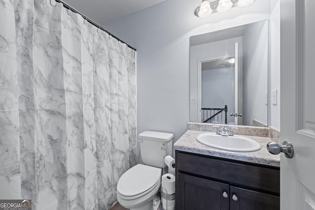 full bathroom featuring toilet, a shower with shower curtain, and vanity