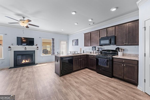 kitchen featuring dark brown cabinetry, a peninsula, ornamental molding, light wood-type flooring, and black appliances