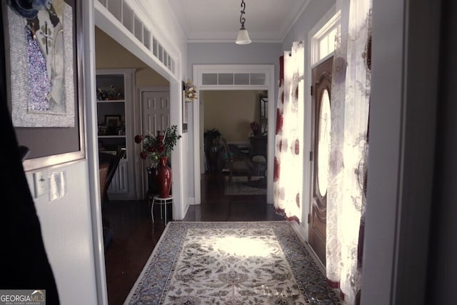 hallway with wood finished floors and ornamental molding