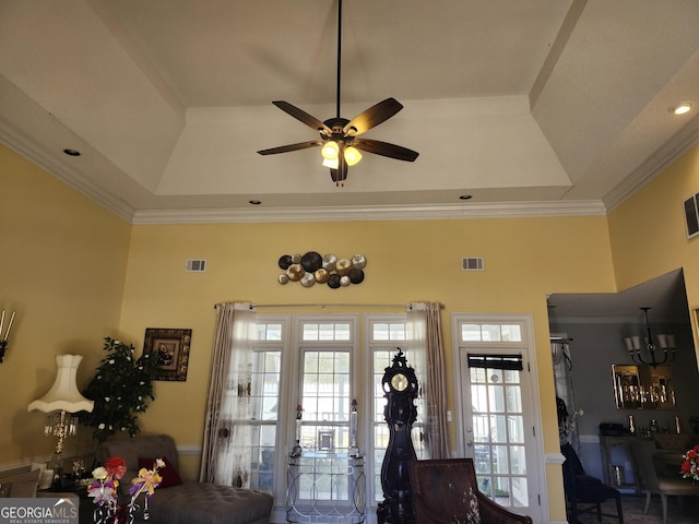 interior space featuring visible vents, a tray ceiling, and ornamental molding