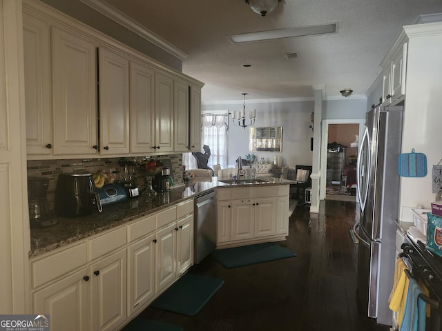 kitchen featuring a sink, stainless steel appliances, a peninsula, and ornamental molding