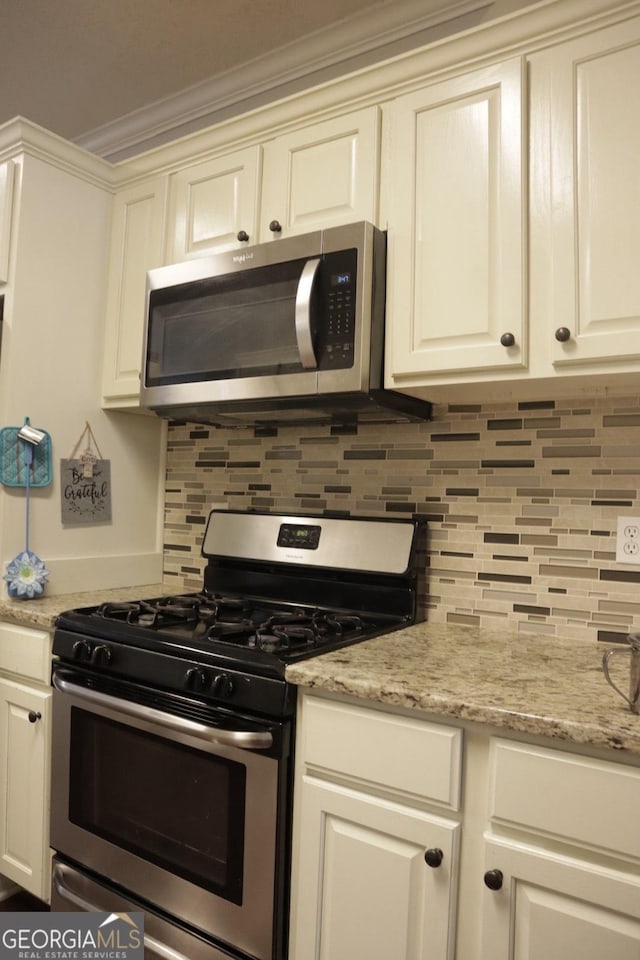 kitchen with crown molding, light stone countertops, decorative backsplash, white cabinets, and stainless steel appliances