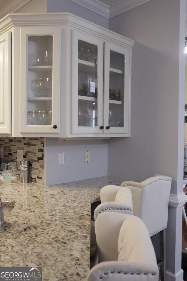 bar featuring decorative backsplash and crown molding