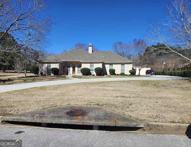 view of front of home with a front yard and a chimney