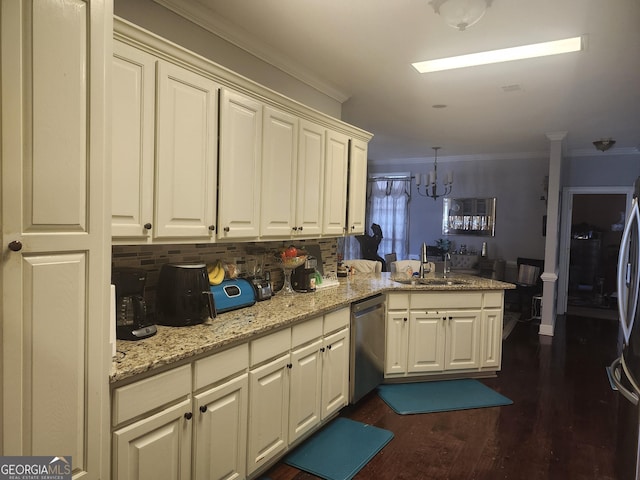 kitchen featuring appliances with stainless steel finishes, crown molding, a peninsula, and a sink